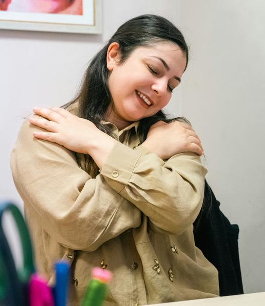 An image of a young woman giving herself a hug